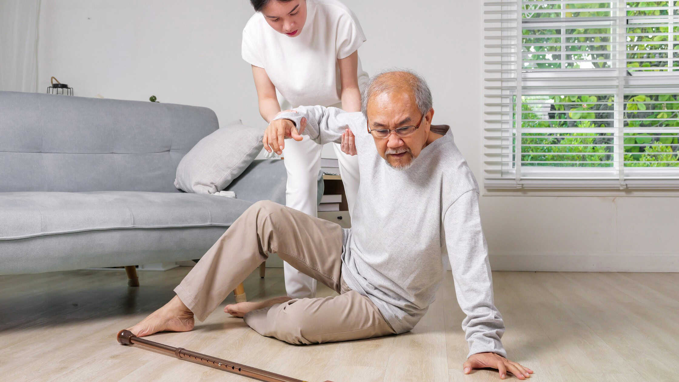 Older man being helped up after a fall