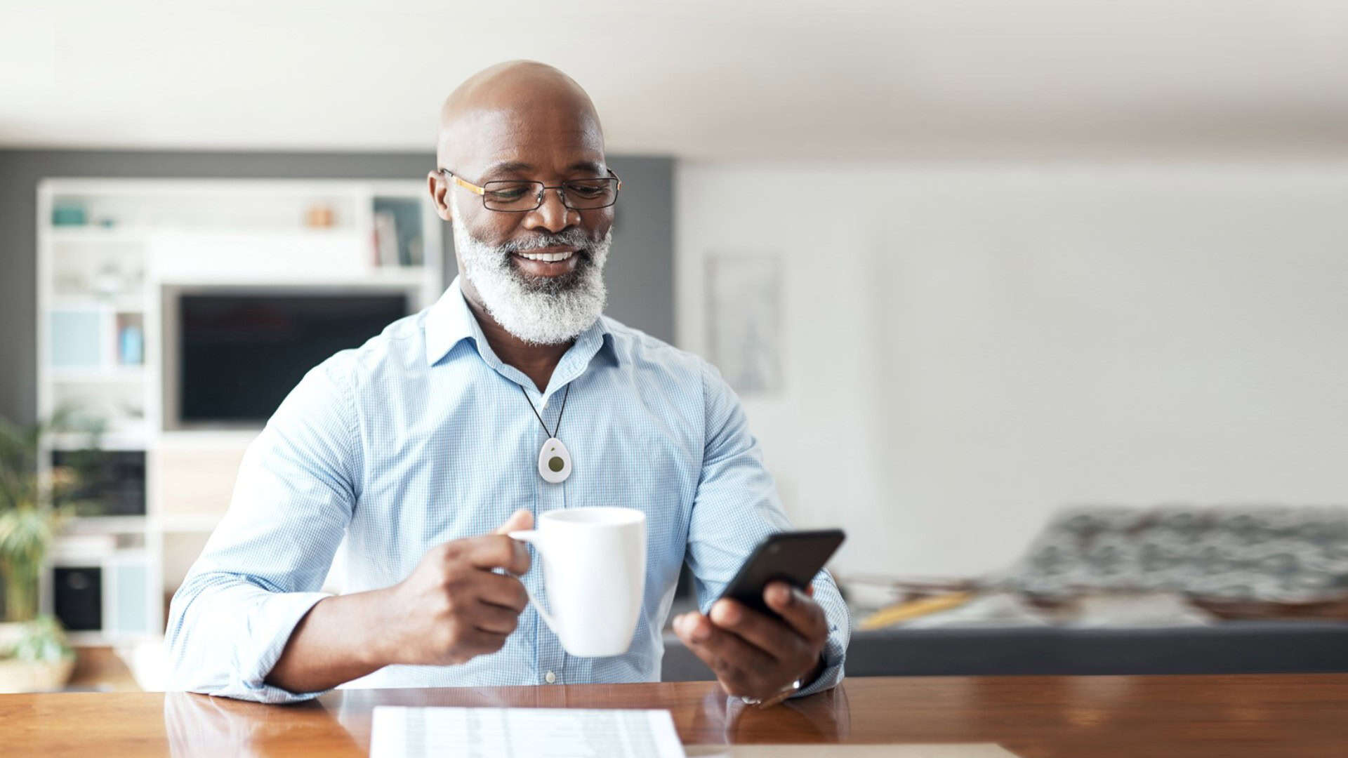 Man drinking coffee and wearing lifeline button Man drinking coffee and wearing lifeline button