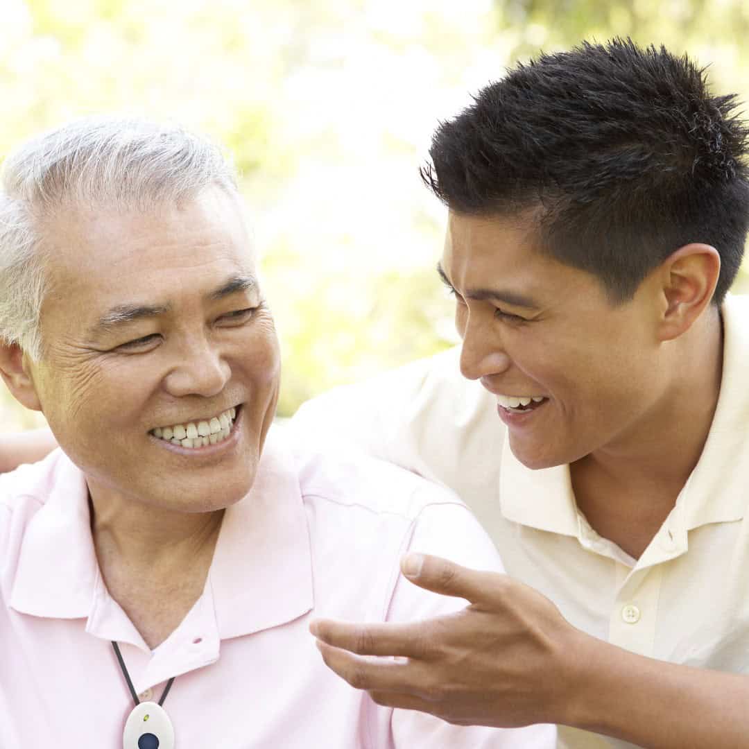 Older man wearing lifeline talking to son Older man wearing lifeline talking to son