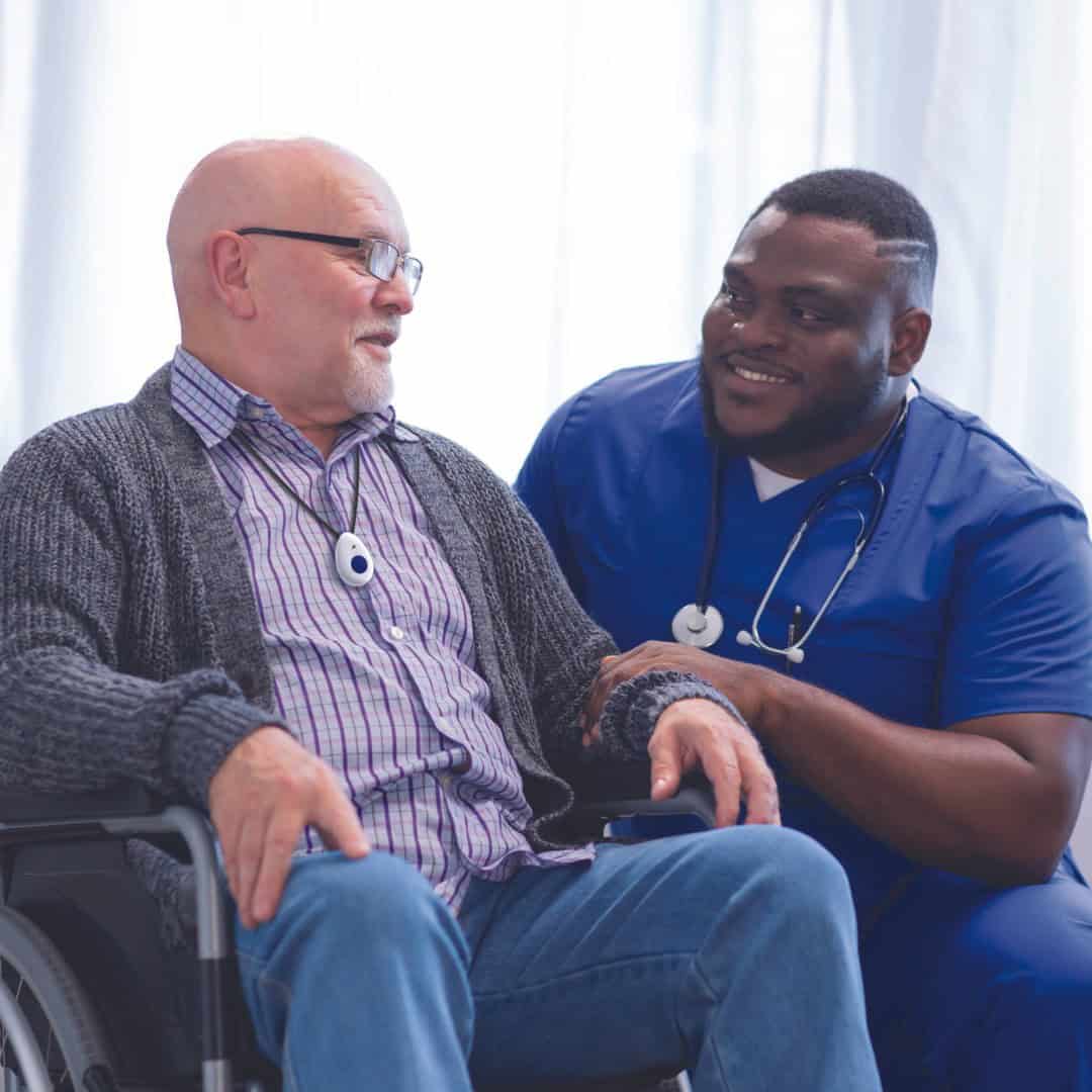 Man in wheelchair talking to healthcare professional Man in wheelchair talking to healthcare professional