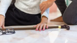 Common Causes of Falls - Older women on ground and somebody is helping her up